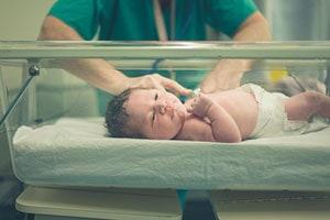 Doctors examining baby after birth