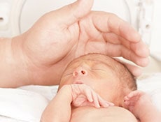 Portrait of newborn baby sleeping inside incubator